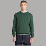 Maglione Timberland verde girocollo indossato, con piccolo logo sul petto