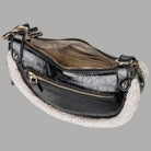 Borsa a spalla nera con cerniere multiple, interno visibile e bordo teddy chiaro
