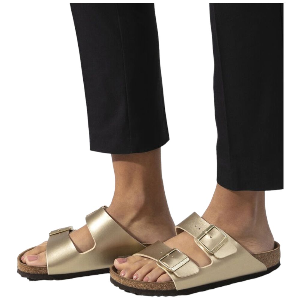 Ciabatte Birkenstock Arizona oro indossate, pantaloni neri e fibbie lucide