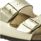 Ciabatte Birkenstock Arizona oro, dettaglio fascia con fibbie e logo sulla tomaia