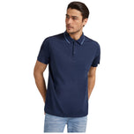 Polo blu con colletto a contrasto e patta con bottoni, vista frontale.